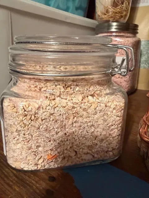 Cream-colored bath salts in a glass jar.