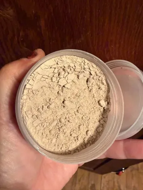 An open jar of tan clay powder for Katrinia's mud mask.